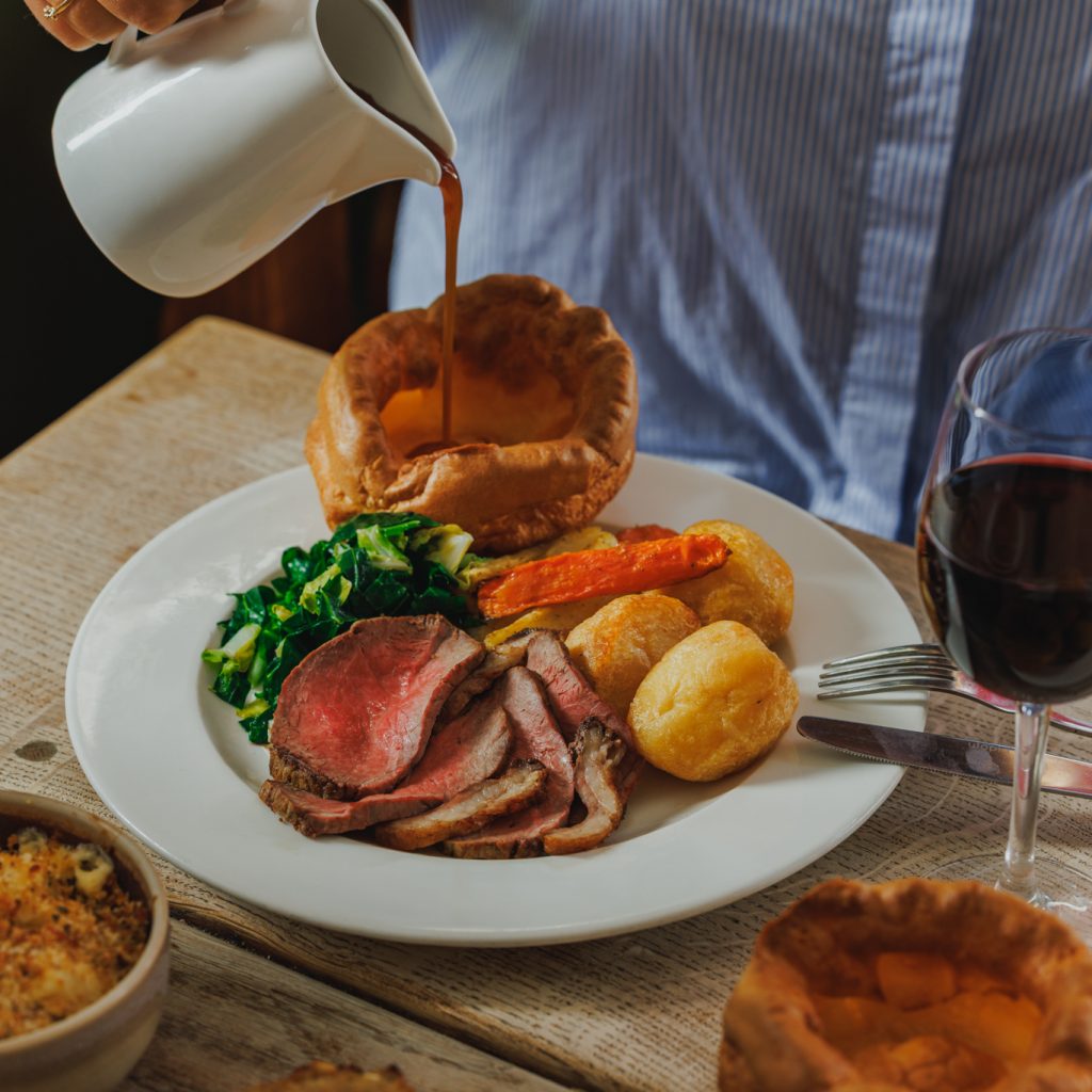 Beef roast dinner, guest pouring gravy